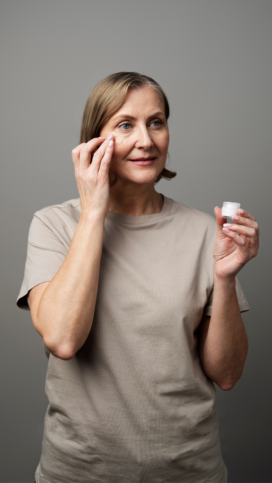 Portrait of an Older Woman Using Facial Moisturizer For Aging Skin